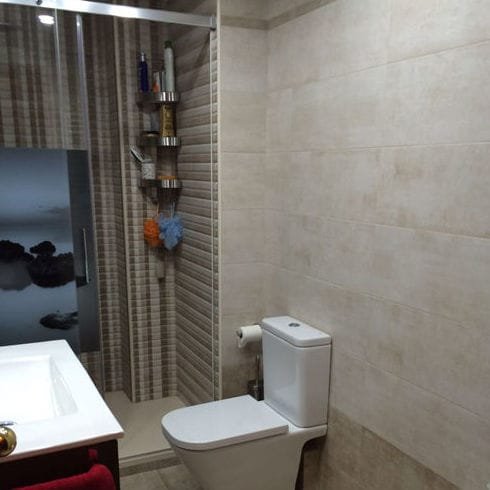 Baño con ducha y revestimientos en tonos grises en Móstoles