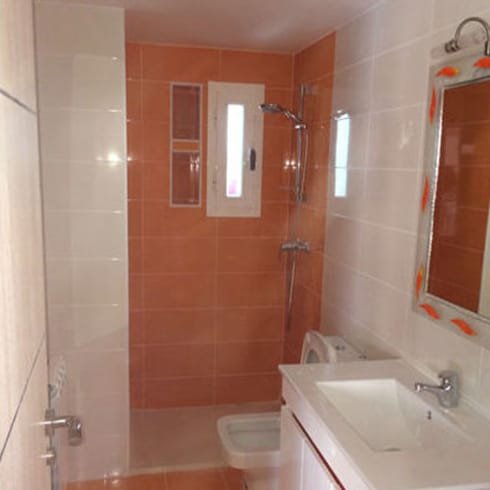Baño con ducha y revestimiento naranja en Móstoles